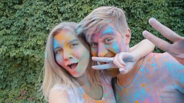 Boldog fiatal pár játék a színes festékek - Felvétel, videó