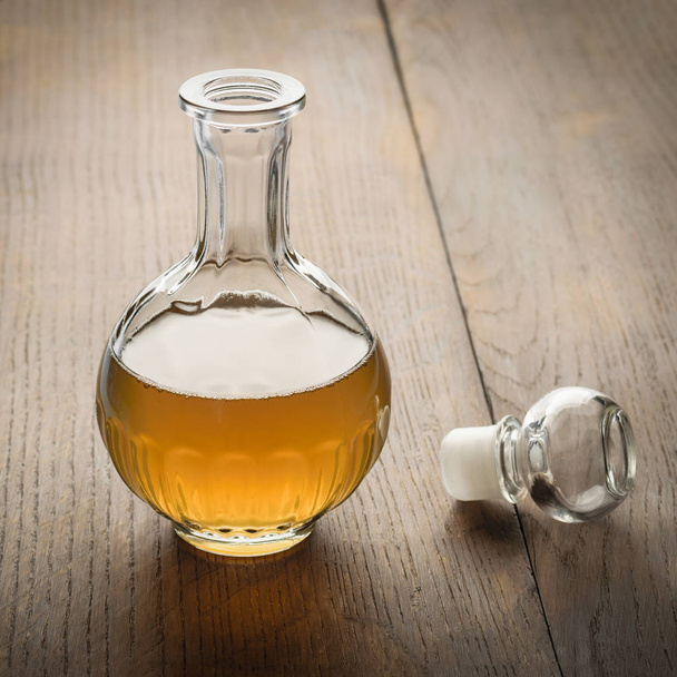 Decanter of apple cider vinegar on a wooden table. - Foto, Imagen