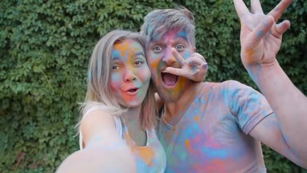 Happy νεαρό ζευγάρι παίζει με πολύχρωμα χρώματα - Πλάνα, βίντεο