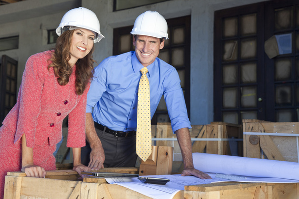 Hombre y mujer en sombreros duros en el sitio de construcción
 - Foto, Imagen