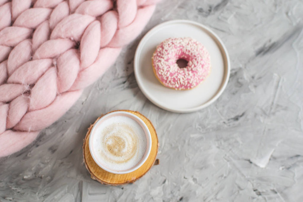 Pohár s cappuccino, prstencový, růžové pastelové obří deku, květiny, ložnice, ranní koncept - Fotografie, Obrázek