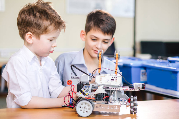 Two brothers kids playing with robot toy at school robotics class, indoor. - Φωτογραφία, εικόνα