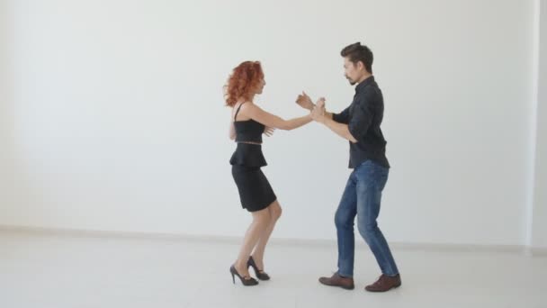Beauty young couple dancing social dance in a white room. Kizomba or bachata or semba or taraxia - Felvétel, videó