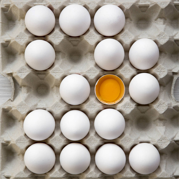 Gebarsten eieren onder andere kippeneieren in kartonnen ei doos, bovenaanzicht. Van bovenaf leggen bovenaanzicht, plat. - Foto, afbeelding