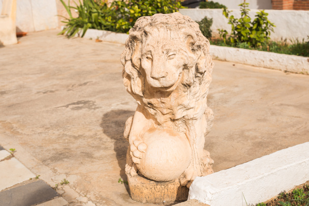 Stone lion statue. Marble Sculpture of a lion on pedestal - Фото, изображение
