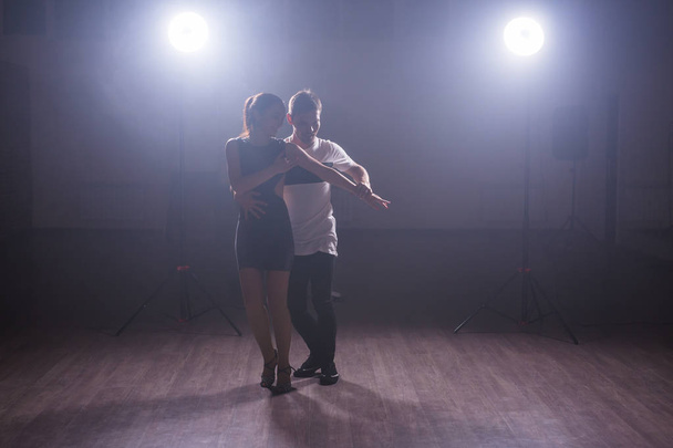 Young couple dancing latin dance Bachata, merengue, salsa. Two elegance pose in dance class - 写真・画像