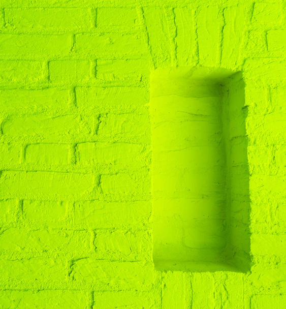 Modern vintage lime green stone brick wall texture background with empty window frame work - Photo, Image