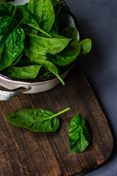 Fresh organic leaves of baby spinach on rustic background with copy space as a organic food concept - Foto, Imagem