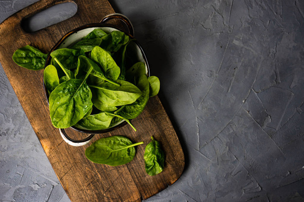 Fresh organic leaves of baby spinach on rustic background with copy space as a organic food concept - Foto, Imagen