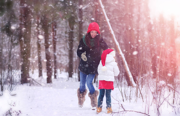 A winter fairy tale, a young mother and her daughter ride a sled - Photo, Image