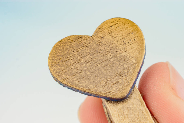 Ícone de forma de coração anexado a um pano na mão
 - Foto, Imagem