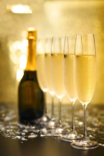 Many glasses of champagne in a line. Gold background - Photo, Image