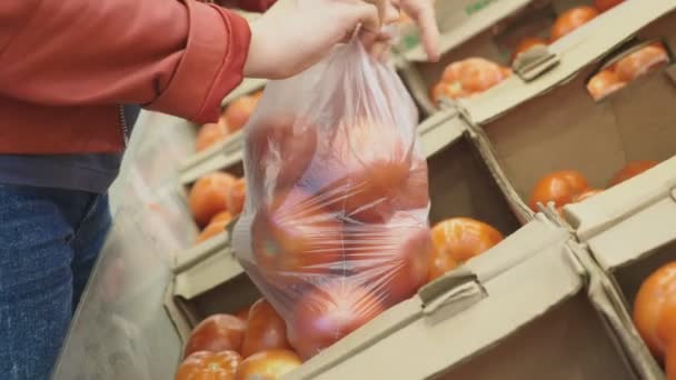 A woman in a supermarket buying vegetables - Záběry, video