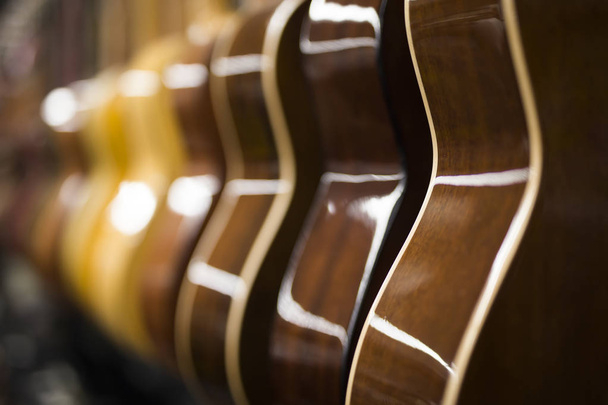 Крупним планом вид на акустичні гітари в ряд в музичному магазині
 - Фото, зображення