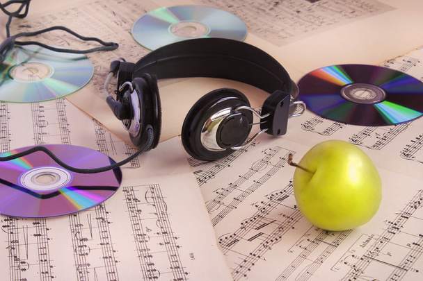 kuulokkeet, CD-levyt, nuotit ja omena
 - Valokuva, kuva