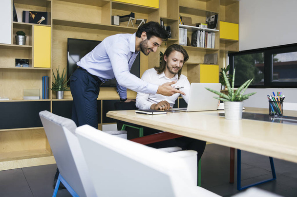 Két fiatal üzletemberek dolgozik laptop iroda - Fotó, kép
