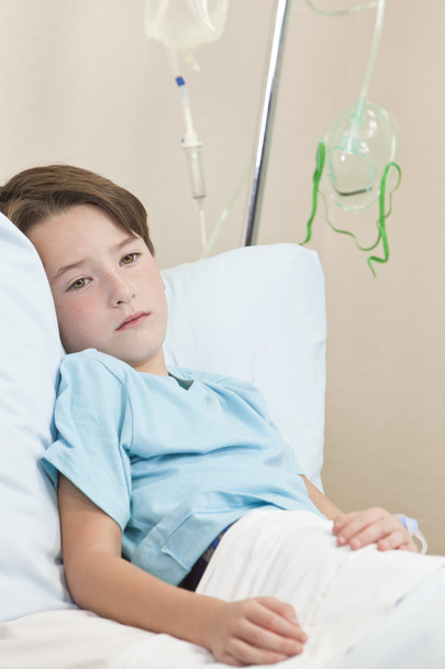 Fiatal fiú gyermek beteg kórházi ágyon - Fotó, kép