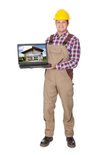 Construction worker presenting laptop - Photo, image