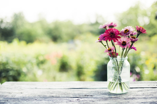 fresh chrysanthemums in jar on rustic table outdoors - Фото, зображення