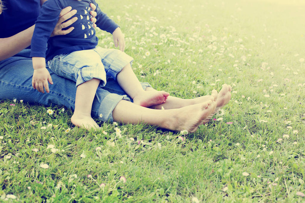 low section view of mother and son feet on grass - Foto, imagen