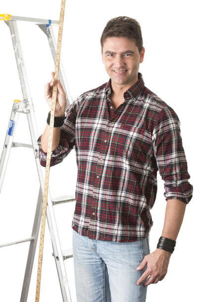 Bâtisseur mâle mesurant avec règle en bois
 - Photo, image