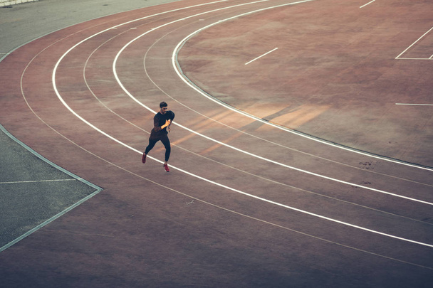Top view Athlete running on running track. Runner sprinting on red running track in stadium - Фото, зображення