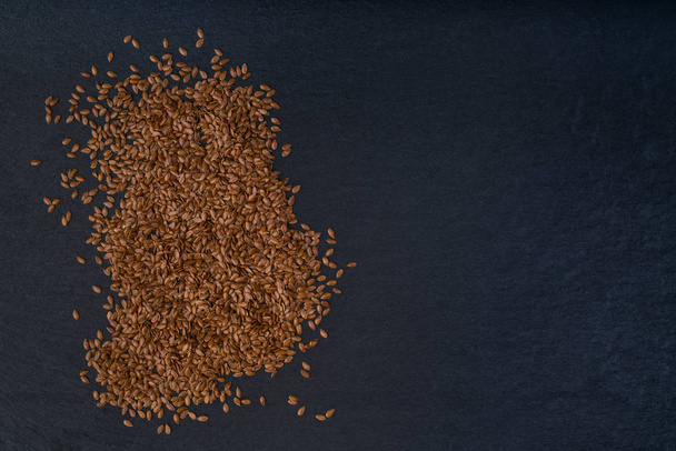 flax seeds on a black background. Top view - Photo, Image