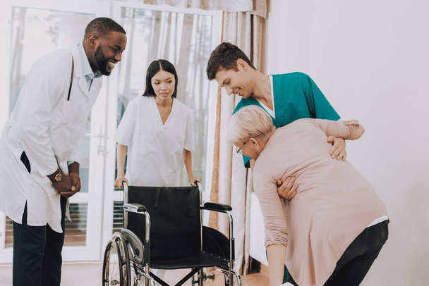 Nurse Helps. Elderly Woman. Get Out Bed. Get Into Wheelchair. Woman Feels Weak. Doctor in Clinic. Doctor Helps get up. Patient. Patient on a Wheelchair. Nursing Home. Rehabilitation. - Photo, image