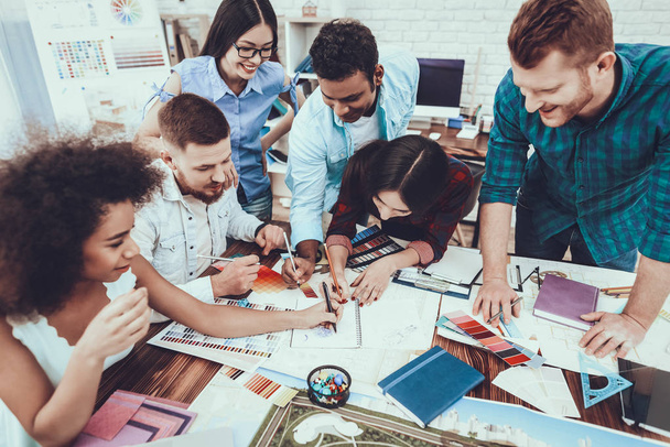Teamwork. Young Designers. Different Races. Project. Cooperation. Group. Generate Idea. Spend Brainstorming. Work. Table. Large Bright Office. Discuss. Colors for Design. Samples. Schemes. - Foto, Imagen