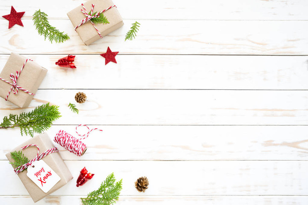 Weihnachten und Neujahr. Ansicht der Geschenkbox, Tannenzapfen, roter Stern und Glocke auf weißem Hintergrund. - Foto, Bild