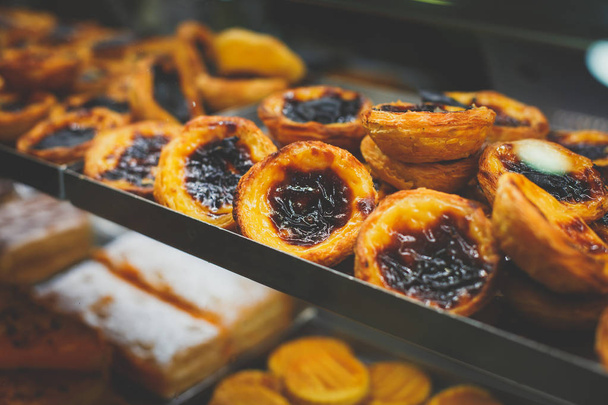 Traditional Portuguese egg tart pasty cakes, dessert Pasteis de nata with different portuguese pastry on the cafe store window, pastel de nat - 写真・画像