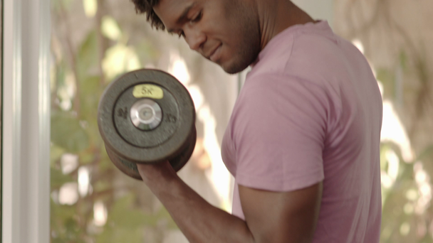 Sport et plaisir, jeune homme noir et athlète prenant des poids de l'étagère dans le club de fitness
 - Séquence, vidéo