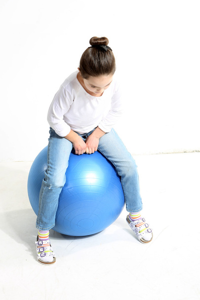Little girl sitting on the ball - Фото, изображение