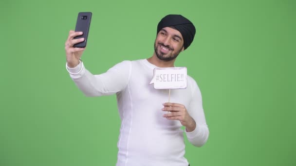 Młody szczęśliwy Brodaty Indyjski człowiek biorąc selfie z papieru znak - Materiał filmowy, wideo