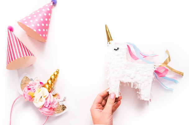 Sombreros de fiesta y diadema de unicornio sobre fondo blanco
. - Foto, Imagen