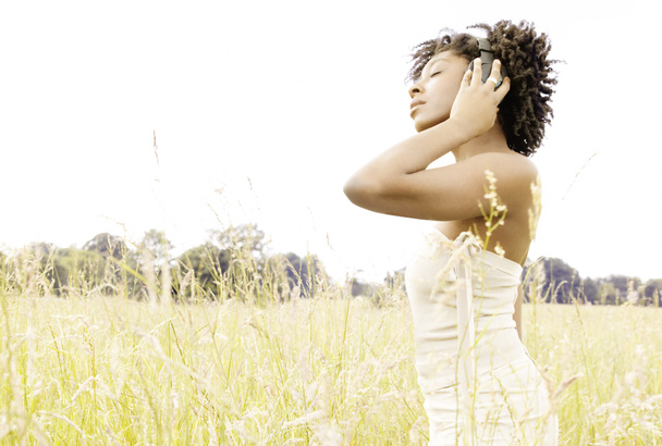 atrakcyjny czarny kobieta korzystających, słuchając muzyki z jej słuchawki - Zdjęcie, obraz