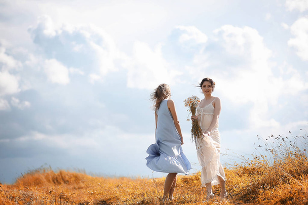Duas meninas em vestidos no campo de outono
 - Foto, Imagem