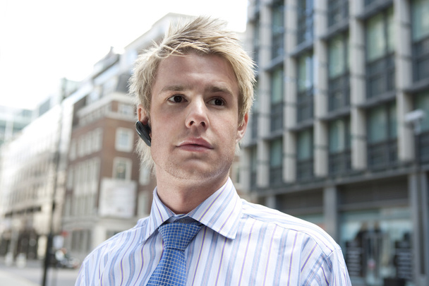 Young businessman using a hands free device to speak on the phone - Photo, Image