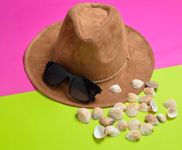 A koncepció egy resort a tengerparton. Úgy érezte, kalap, napszemüveg, színes papír alapon tengeri kagylókból - Fotó, kép