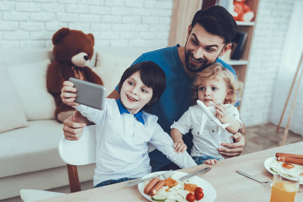 Selfi. Father Two Boys. Having Breakfast. Man. Juice. Scrambled Eggs. Sandwich. Happy Together. Delisious Food. Smile. Spends Time. Leisure Time. Smiling Kids. Father. Home Time. Child on Chair. - Foto, imagen