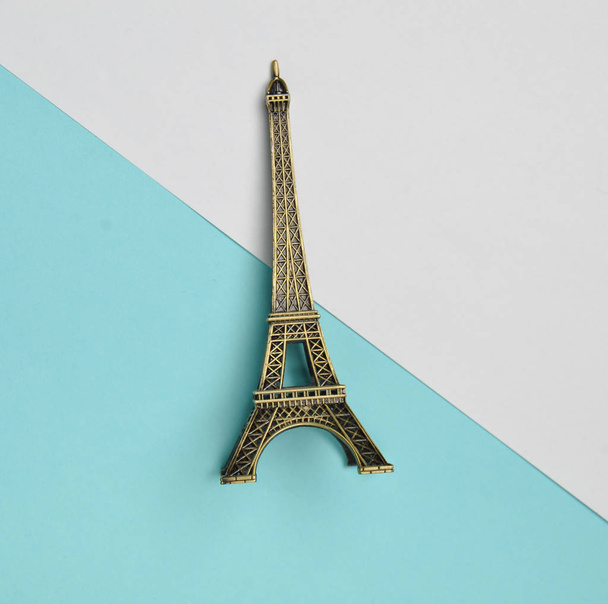 Une statuette souvenir de la Tour Eiffel sur fond pastel bleu blanc. Vue de dessus. Tendance minimaliste
 - Photo, image