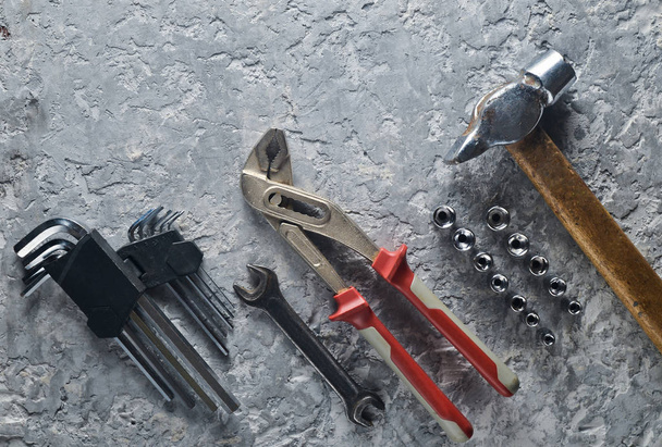 Werkende tool op een grijze concrete achtergrond. Steekringsleutels, een hamer, hex toetsen. Bovenaanzicht, kopie ruimte - Foto, afbeelding