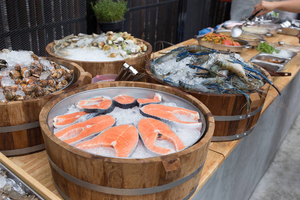 close up slide salmão peixe, molusco de camarão e bar buffet no gelo para o cliente
 - Foto, Imagem