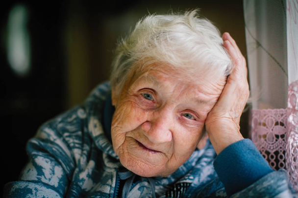 grauhaarige ältere Frau, die in die Kamera blickt. - Foto, Bild