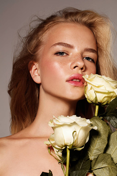 Beauty young model with white rose. Perfect glow skin. Blonde hair. Fresh look. - Fotografie, Obrázek