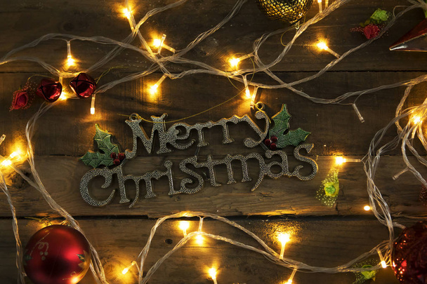 Κάτοψη του χριστουγεννιάτικο στολίδι με καλά Χριστούγεννα κείμενο πάνω στο ξύλινο τραπέζι - Φωτογραφία, εικόνα