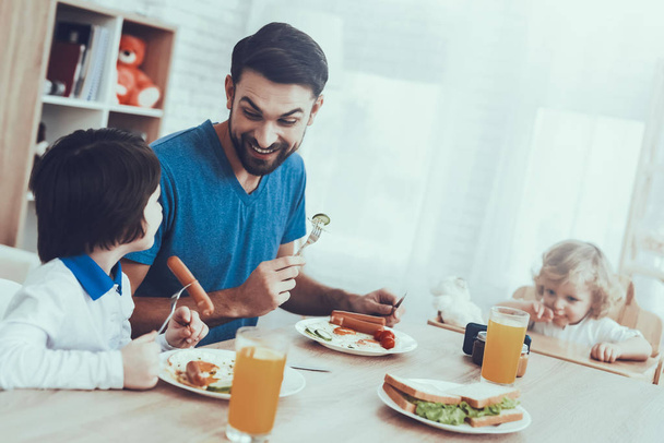 Sausages. Having Breakfast. Juice. Father Two Boys. Scrambled Eggs. Sandwich. Happy Together. Delisious Food. Smile. Spends Time. Leisure Time. Smiling Kids. Father. Man. Home Time. Child on Chair. - Fotoğraf, Görsel