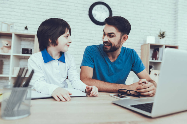 Laptop. Homework. Upbringing. Looks After Children. Spends Time. Happy Together. Leisure Time. Smiling Kids. Father. Father Two Boys. Man. Home Time. Baby with Bright Hair. Works at Home. - 写真・画像