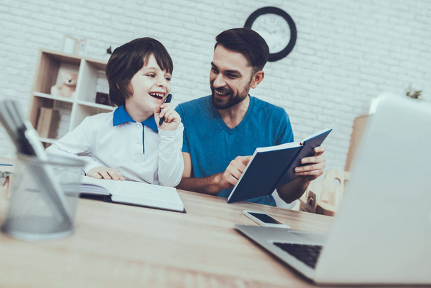 Smiling Kids. Father. Homework. Laptop. Upbringing. Looks After Children. Spends Time. Happy Together. Leisure Time. Man. Home Time. Baby with Bright Hair. Works at Home. Father Two Boys. - 写真・画像