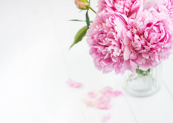 Florero con flores de peonía rosa sobre una mesa de madera blanca
 - Foto, imagen